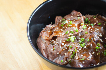 Wagyu beef Donburi with Japanese rice in black bowl.