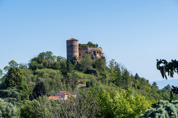 Gros plan du château de Busséols perché en haut de sa montagne avec sa tour de défense par une...
