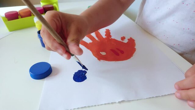 Little child draws a fish, concept of education in the kindergarten