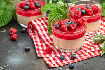 Raspberry sorbet with whipped cream and mint. Italian dessert on a dark background in small jars. place for text