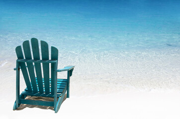 Single wooden chair on white sand beach. Solo travellng concept.