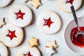 Obraz na płótnie Canvas Christmas strawberry linzer cookies on gray background. Festive dessert, winter treat.