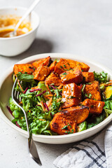 Baked sweet potato salad bowl with mustard dressing. Vegan food concept.