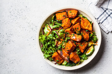 Baked sweet potato salad bowl with mustard dressing. Vegan food concept.