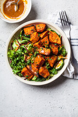 Baked sweet potato salad bowl with mustard dressing. Vegan food concept.