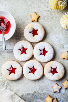 Christmas tree from strawberry linzer cookies on gray background. Festive dessert, winter treat.
