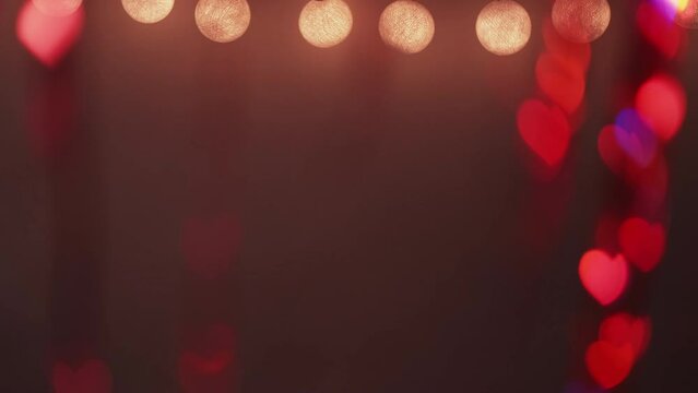 Romantic background. Valentine day. Lights decoration. Yellow led string neon red blue color bokeh hearts glow on defocused dark abstract texture.