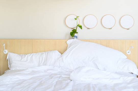 White bedding with plant decoration in minimal hotel room