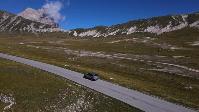 Panoramic view of the road in the mountains along which the car rides. Gran Sasso mountain, in Abruzzo region, central Italy, summer day in the mountains. Tourist destination in Italy