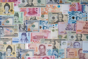 Closeup of variety banknote around the world include dollar Yuan Baht Peso Won for currency exchange or Forex investment and money payment transfer concept. - obrazy, fototapety, plakaty