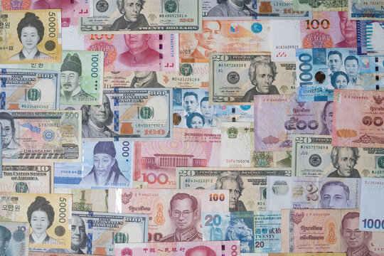 Closeup of variety banknote around the world include dollar Yuan Baht Peso Won for currency exchange or Forex investment and money payment transfer concept.