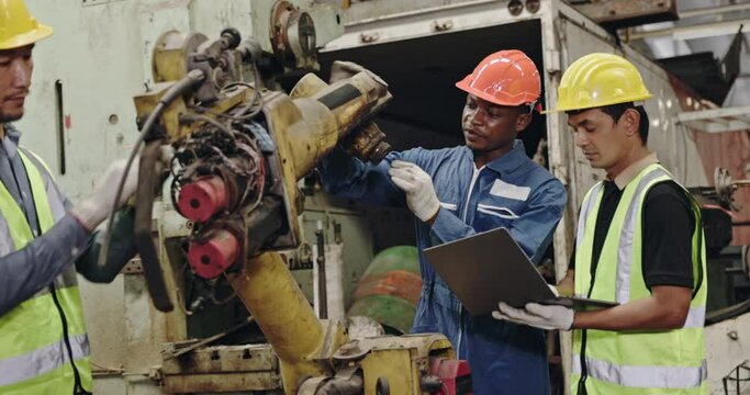 Group of machine technicians are profession inspect the electrical equipment in factory. Industrial plant engineers plan machine maintenance. African American workers work with Asian team Blue collar