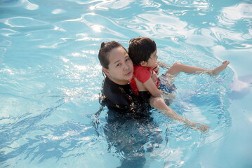 Mother and son playing in swimming pool