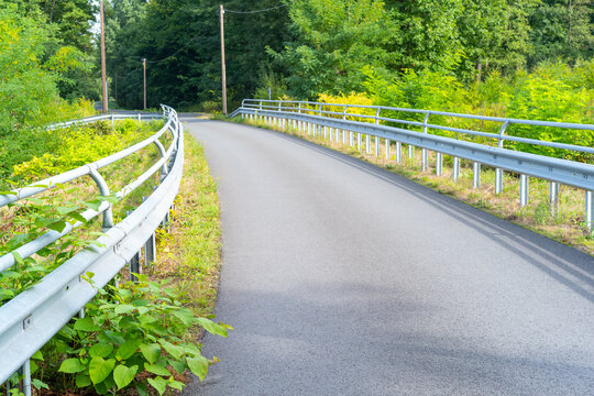 Road With Guardrails Leads Into The Forest