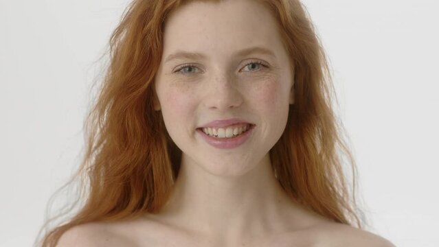 Beauty Woman face Portrait. Beautiful Spa model Girl with Perfect Fresh Clean Skin. Caucasian Female with Ginger haircut looking at camera and start smiling. Youth and Skin Care Concept. Isolated on a