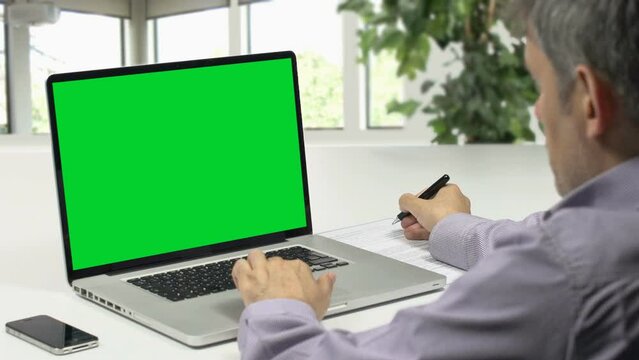 businessman working on laptop green screen
