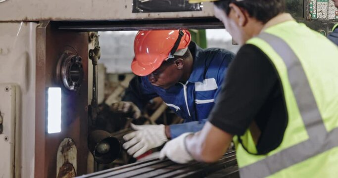 Group of machine technicians are profession inspect the electrical equipment in factory. Industrial plant engineers plan machine maintenance. African American workers work with Asian team Blue collar