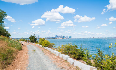Fototapeta na wymiar Hiking on Spectacle Island with a great view of the Boston Skyline in the distance.