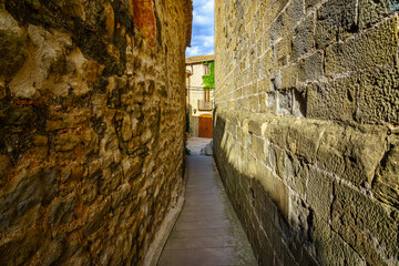 Very narrow alley between old stone houses for the passage of a single person, Madremanya, Girona, Spain.