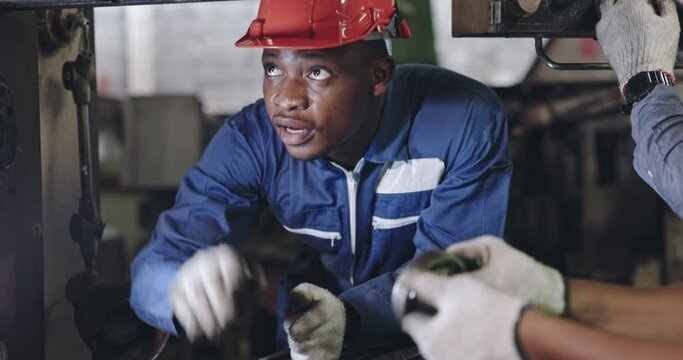 Group of machine technicians are profession inspect the electrical equipment in factory. Industrial plant engineers plan machine maintenance. African American workers work with Asian team Blue collar