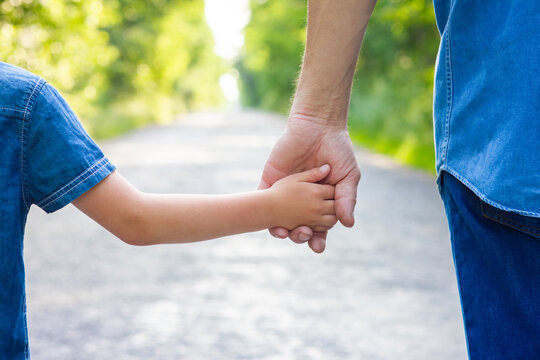 A Hands of happy parent and child on nature on the road in park background