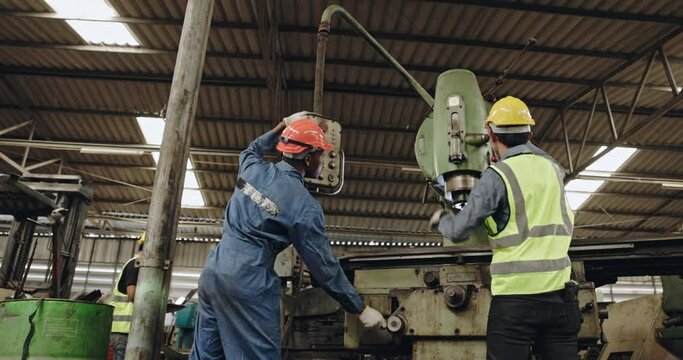 Group of machine technicians are profession inspect the electrical equipment in factory. Industrial plant engineers plan machine maintenance. African American workers work with Asian team Blue collar