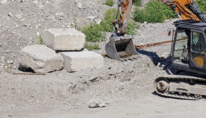 A mechanical shovel of an excavator at work in a river bed