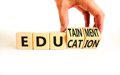 Education and edutainment symbol. Concept words Education and edutainment on wooden cubes. Teacher hand. Beautiful white table white background. Education and edutainment concept. Copy space.