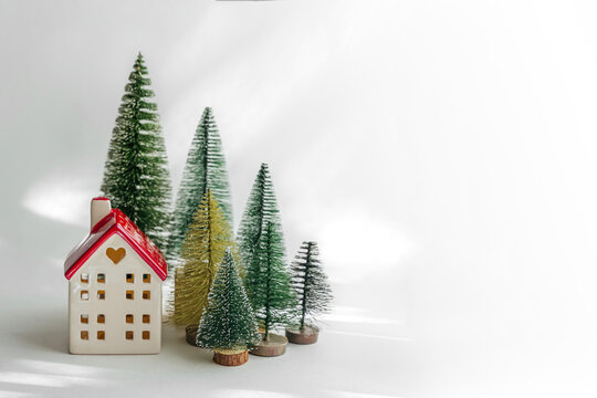 Miniature houses and fir trees on white background. Winter cute landscape. Cozy small world. Christmas decorations, holiday concept. .