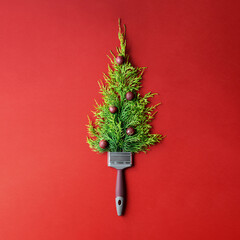 Creative Christmas tree on red paper background with copy space.