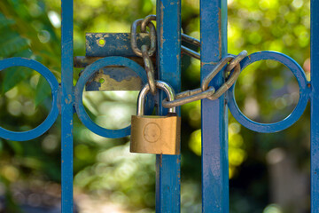Iron lock locked garden green with blue  gate