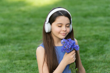 teen girl listen music. child in wireless music headphones. kid listening to music smell flowers
