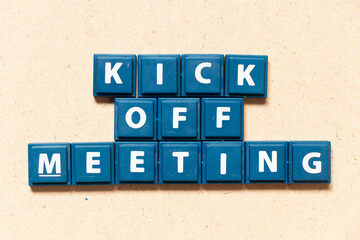 Tile letter in english word kick off meeting on wood background