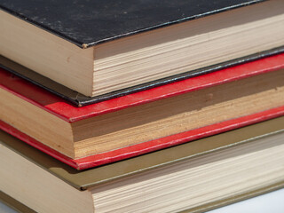 Old dusty hardcover books close-up, focus in the foreground low depth of field