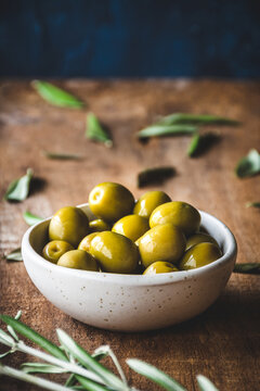 aceitunas verdes en un bol sobre una mesa de madera r&uacute;stica