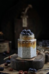 Chia pudding with blueberries in a jar on a wooden board