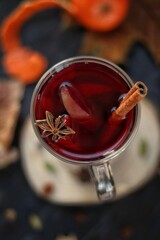 Non-alcoholic mulled wine with orange, cinnamon and honey on a wooden stand. Autumn mood.