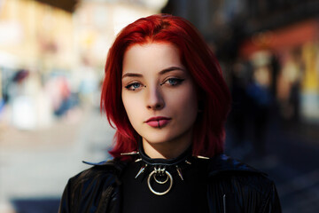 close up young adult woman outside blue eyes with punk spike choker