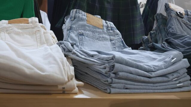 Slow Motion shot of Jeans in the Clothing Store. Close up fabric in market