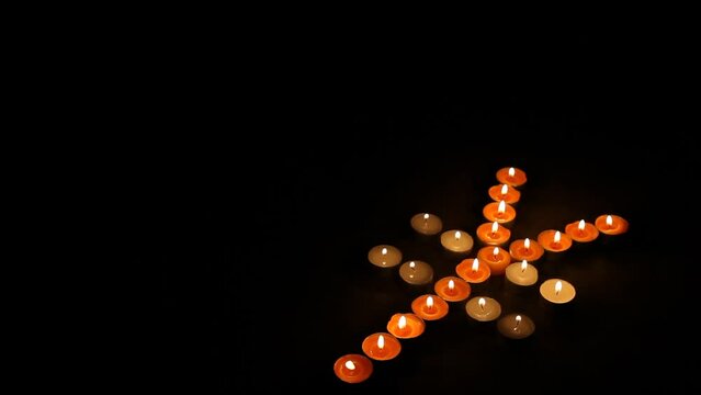 Japanese Yen Symbol Made of Burning Votive Candles Black Background