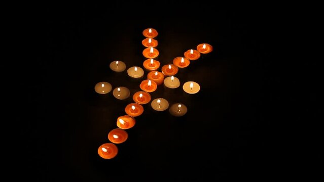 Japanese Yen Symbol Made of Burning Votive Candles Black Background