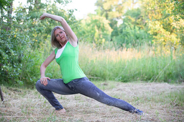 Elderly beautiful woman goes in for sports in nature.