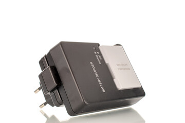 One charger for a camera with an inserted battery, close-up, isolated on a white background.