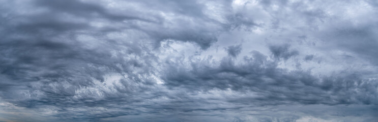 Obraz premium dark blue sky background with fluffy rain clouds. Sky panorama.