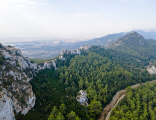 Fototapeta premium Mountain landscape. Kantara in Cyprus. Lots of green trees and beautiful hills. Exotic background. Top view from a drone
