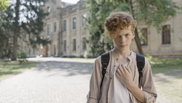 Upset Red Haired Boy Standing Alone In School Yard, Unpopular In Class, No Friends