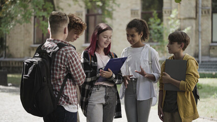 Active school children discussing project in yard, ready to work together, team