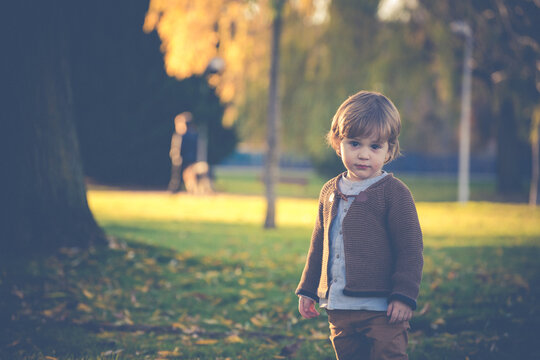 Retro image of a child standing in a park during autumn