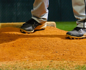 Youth Pitcher Set before pitch during an evening baseball game.