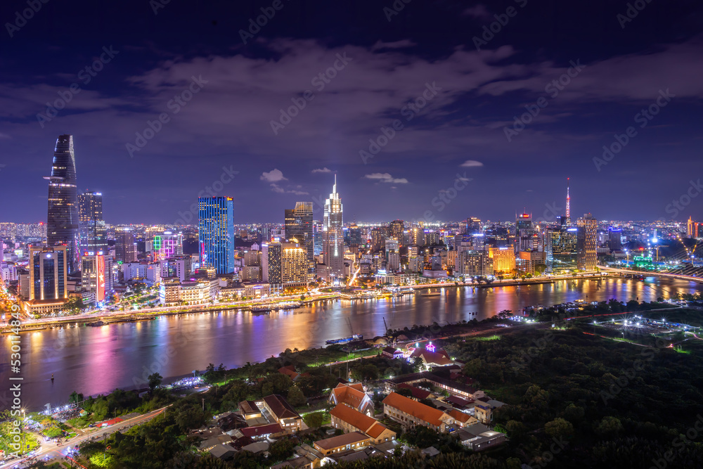 Wall mural Aerial view of Bitexco Tower, buildings, roads, Thu Thiem 2 bridge and Saigon river in Ho Chi Minh city - Far away is Landmark 81 skyscraper. Travel concept.